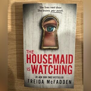 The Housemaid Is Watching by Freida McFadden - Red & White Paperback